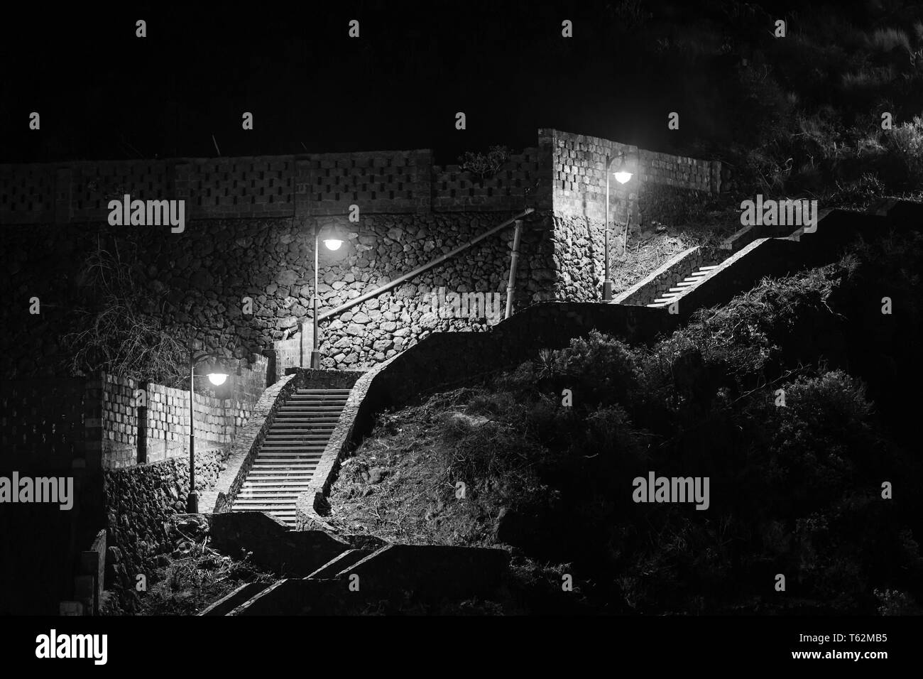 Eine beleuchtete Treppe in Los Cancajos, La Palma, Spanien. Schwarz und Weiß, in der Nacht, die die Treppe führt vom Strand an einer Straße. Stockfoto