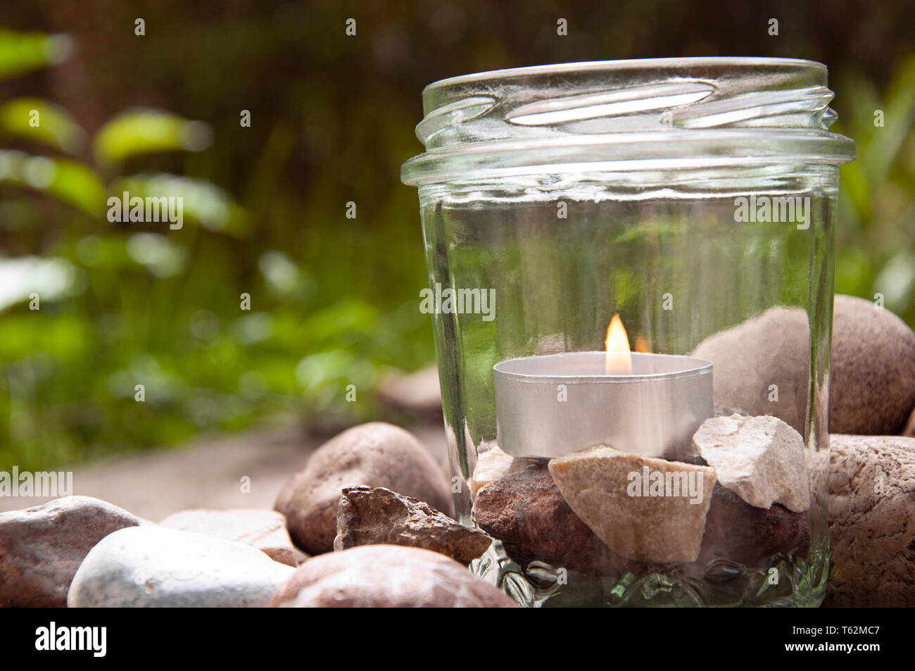 Burning tee Kerze Glas Steine Rechts Gräser Hintergrund   durch jziprian Stockfoto