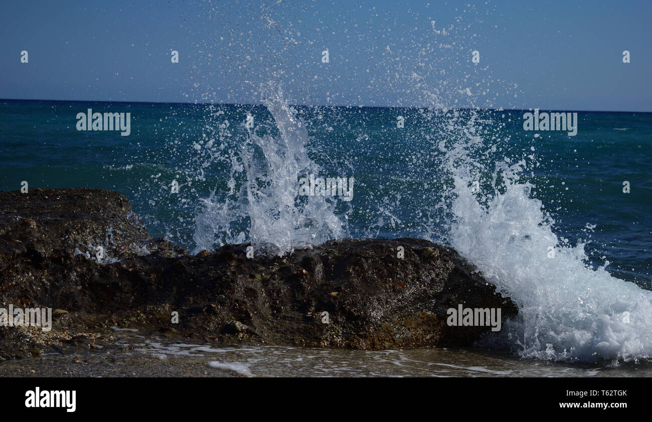 Meer krachend gegen Felsen, verursacht Spritzer, an einem Strand in Mojacar, Südspanien mit einer kurzen Verschlusszeit genommen, um die Aktion zu fangen. Stockfoto
