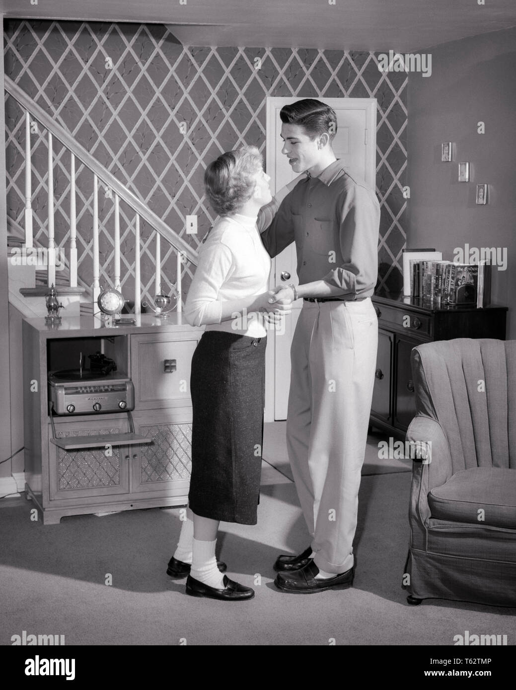 1950 verliebte Teenager Paar Socken tragen, BOBBY UND PENNY MÜSSIGGÄNGER  SCHUHE TANZEN IN SUBURBAN WOHNZIMMER PLATTENSPIELER - j 8416 HAR 001 HARS  SOUND GESUNDHEIT LEBEN ZU HAUSE KOPIEREN RAUM FREUNDSCHAFT IN VOLLER