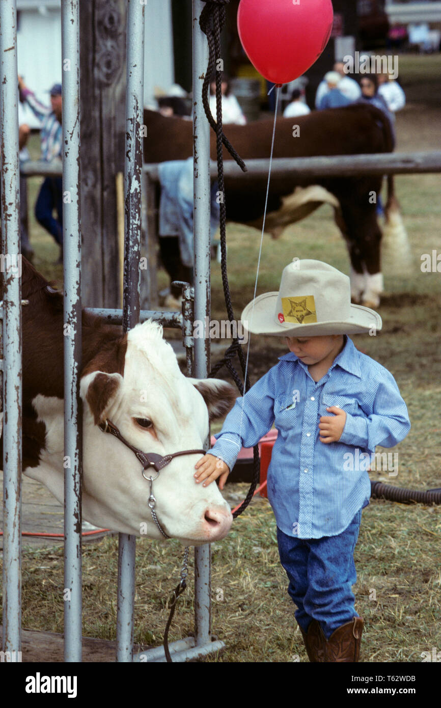 1990 s neugierige junge Junge AN DER COUNTY FAIR TRAGEN COWBOY HUT MIT ROTEN BALLON BERÜHREN GESICHT DER BEFRAGTEN Hereford Rind-kf 31144 LGA001 HARS UNITED STATES KOPIE RAUM VOLLER LÄNGE INSPIRATION VEREINIGTE STAATEN VON AMERIKA FÜRSORGLICHE MÄNNER VERTRAUEN LANDWIRTSCHAFT RINDER GLÜCK KOPF UND SCHULTERN ENTDECKUNG STÄRKE ERHOLUNG AM COUNTY FAIR DER VERBINDUNG HEREFORD KONZEPTIONELLE NEUGIERIG stilvolle Wachstum von Jungfischen KAUKASISCHEN ETHNIE ALTMODISCH Stockfoto