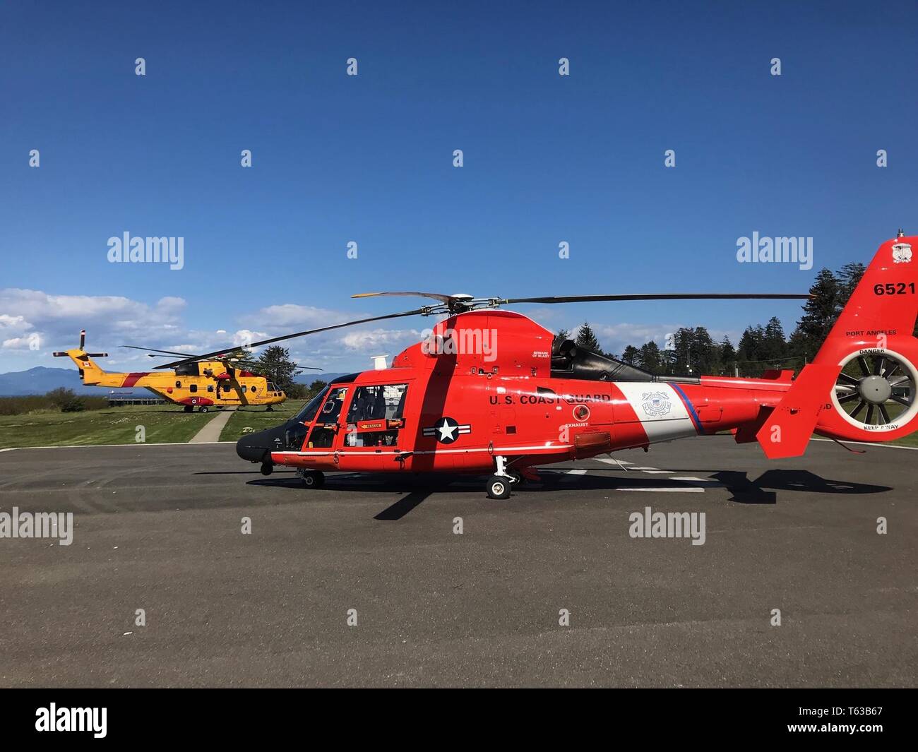 Einem MH-65 Dolphin helicopter aircrew von Coast Guard Sektor Field Office Port Angeles, Washington, Transfers zwei Patienten zu einem Royal Canadian helicopter Aircrew in Neah Bay, Washington, 28. April 2019. Die Küstenwache aircrew gerettet zwei bootsfahrer von einem Strand in der Nähe von Tsusiat Falls, British Columbia nach dem bootsfahrer Eine mayday Anruf getätigt haben. Foto mit freundlicher Genehmigung der US-Küstenwache Sektor Field Office Port Angeles. Stockfoto