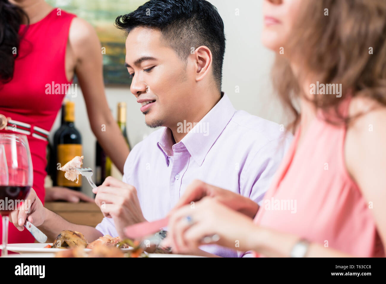 Mann Essen mit Freunden Stockfoto