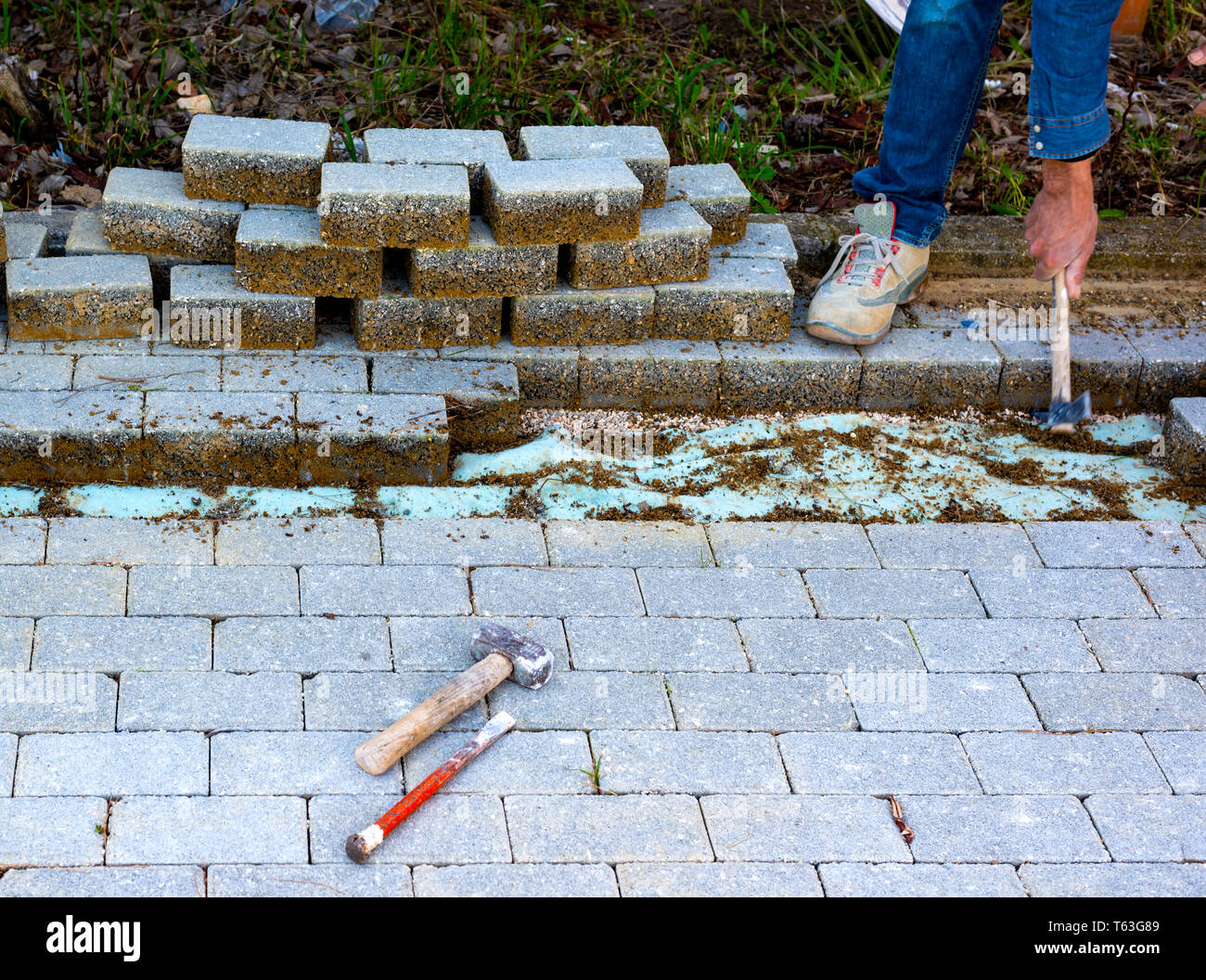 Wartungsarbeiten an ebnet mit Verriegelung Pflastersteine. Baustoffindustrie; konkrete Produkte für Straße oder Gehweg Bau. Stockfoto