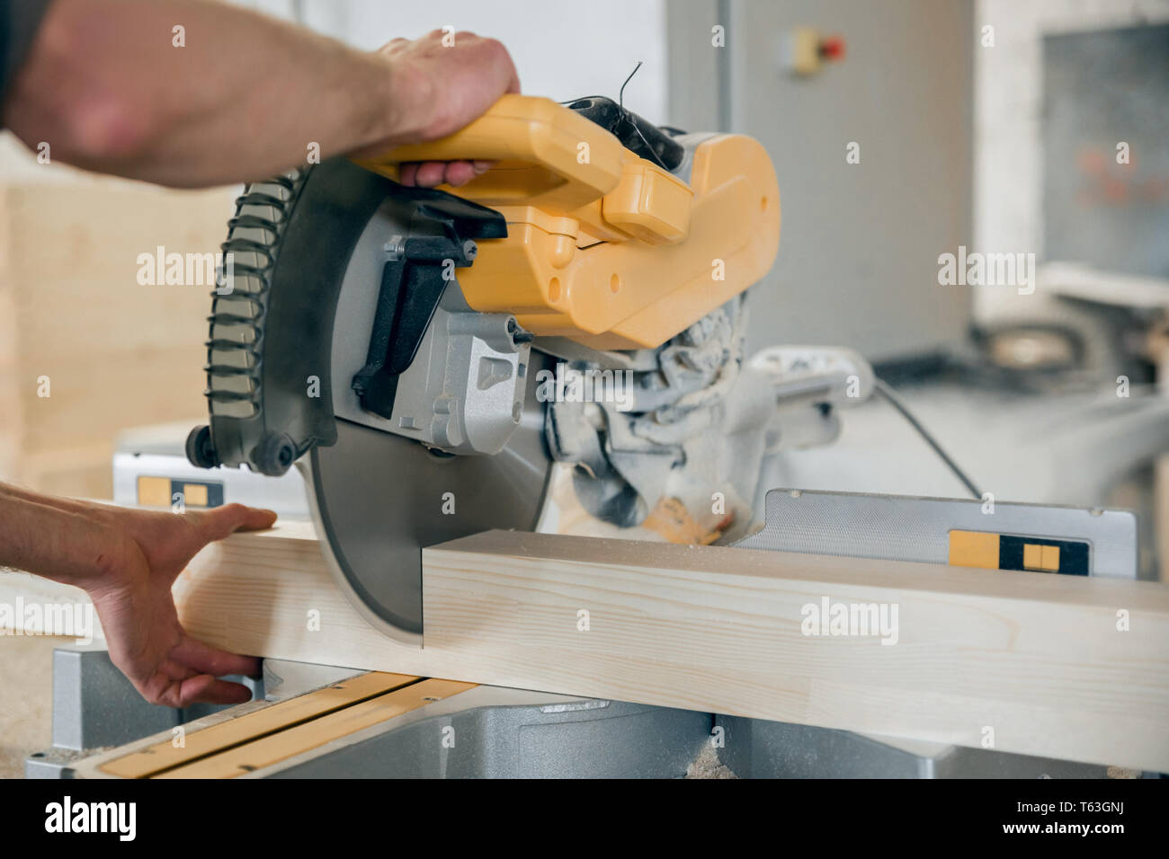 Arbeitnehmer Kürzungen einen Holzbalken Kreissäge. Moderne Ausstattung. Stockfoto