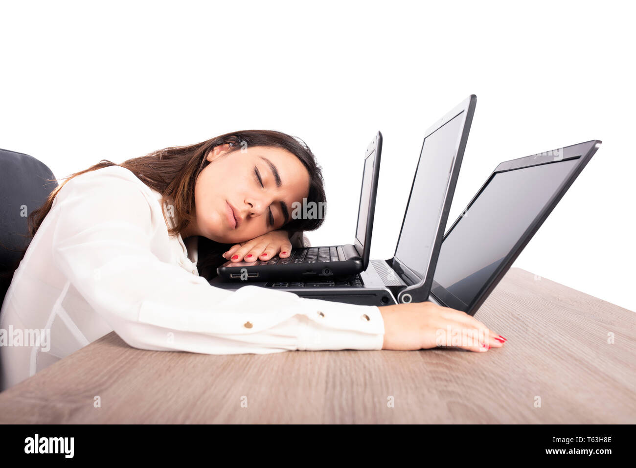 Weibliche Arbeitnehmer einschläft, während gleichzeitig arbeiten an drei Laptops Stockfoto