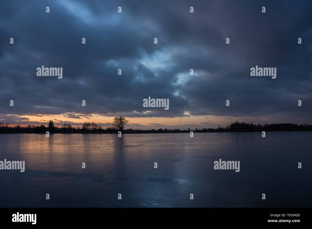 Bewölkter Himmel nach Sonnenuntergang, über einen gefrorenen See - Winter Abend anzeigen Stockfoto