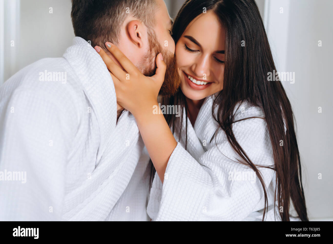 Schöner Mann küssen schöne Frau auf die Wange, während Stockfoto