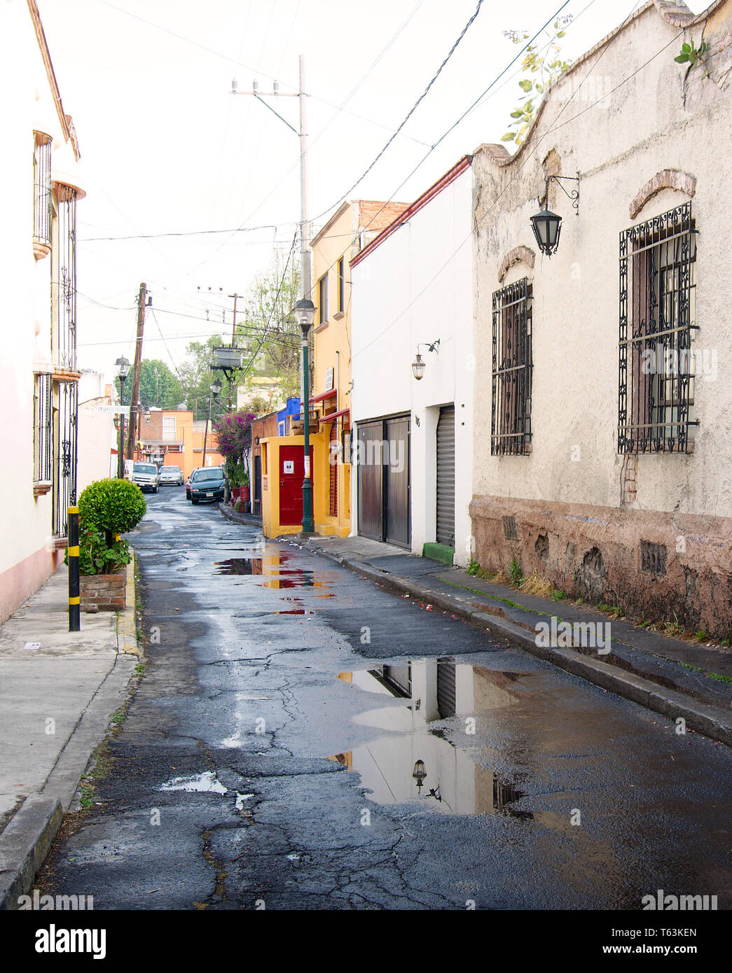 Mexiko City, Mexiko - 2019: Blick auf eine traditionelle Straße mit alten Häusern im historischen Coyoacan Bezirk nach einer kurzen Regen. Stockfoto