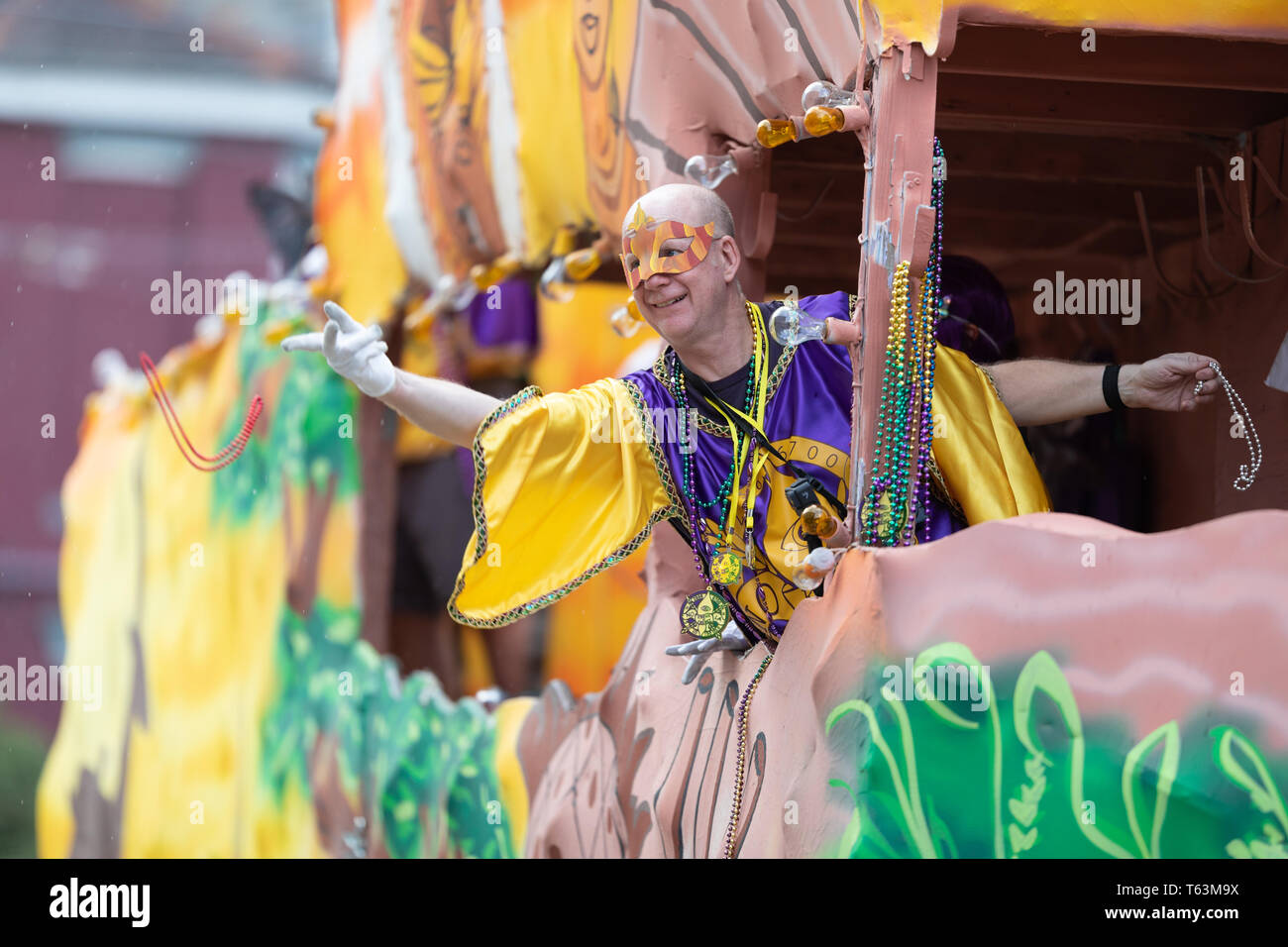 New Orleans, Louisiana, USA - 23. Februar 2019: Mardi Gras Parade, Mann, der traditionellen Kleidung, werfen Beads für die Zuschauer während der mard Stockfoto
