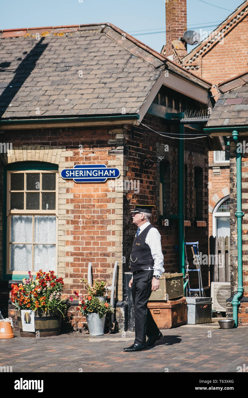 Sheringham, Großbritannien - 21 April, 2019: Leiter in Uniform zu Fuß auf einer Plattform von Sheringham retro Bahnhof. Sheringham ist eine englische Stadt am Meer w Stockfoto