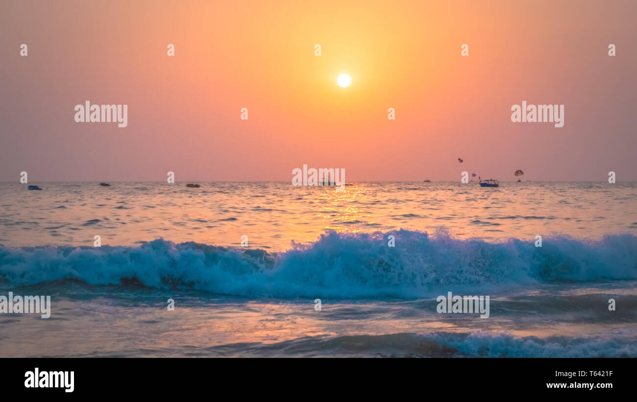 Schönen Sonnenuntergang am Arabischen Meer im Norden von Goa, Indien. Atemberaubenden Sonnenuntergang hinter dem Meer mit Wellen Szene am Calangute Beach in der Nähe von Candolim in Goa. Stockfoto