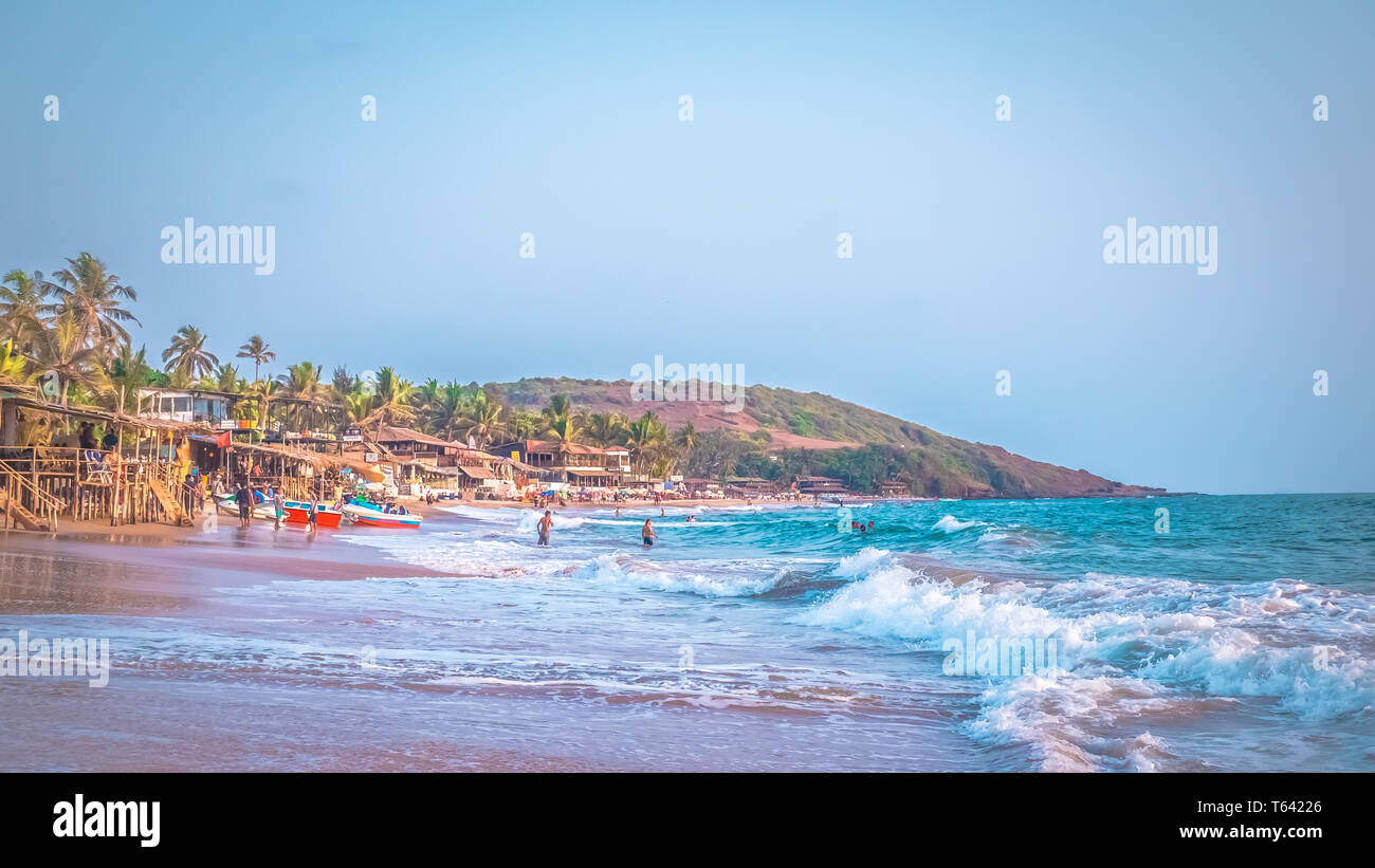 Schöne Anjuna Beach im Norden von Goa, Indien. Beliebte strand ferien Destination in Goa mit blau Arabische Meer Wellen, Felsen, und typische Strand Stockfoto
