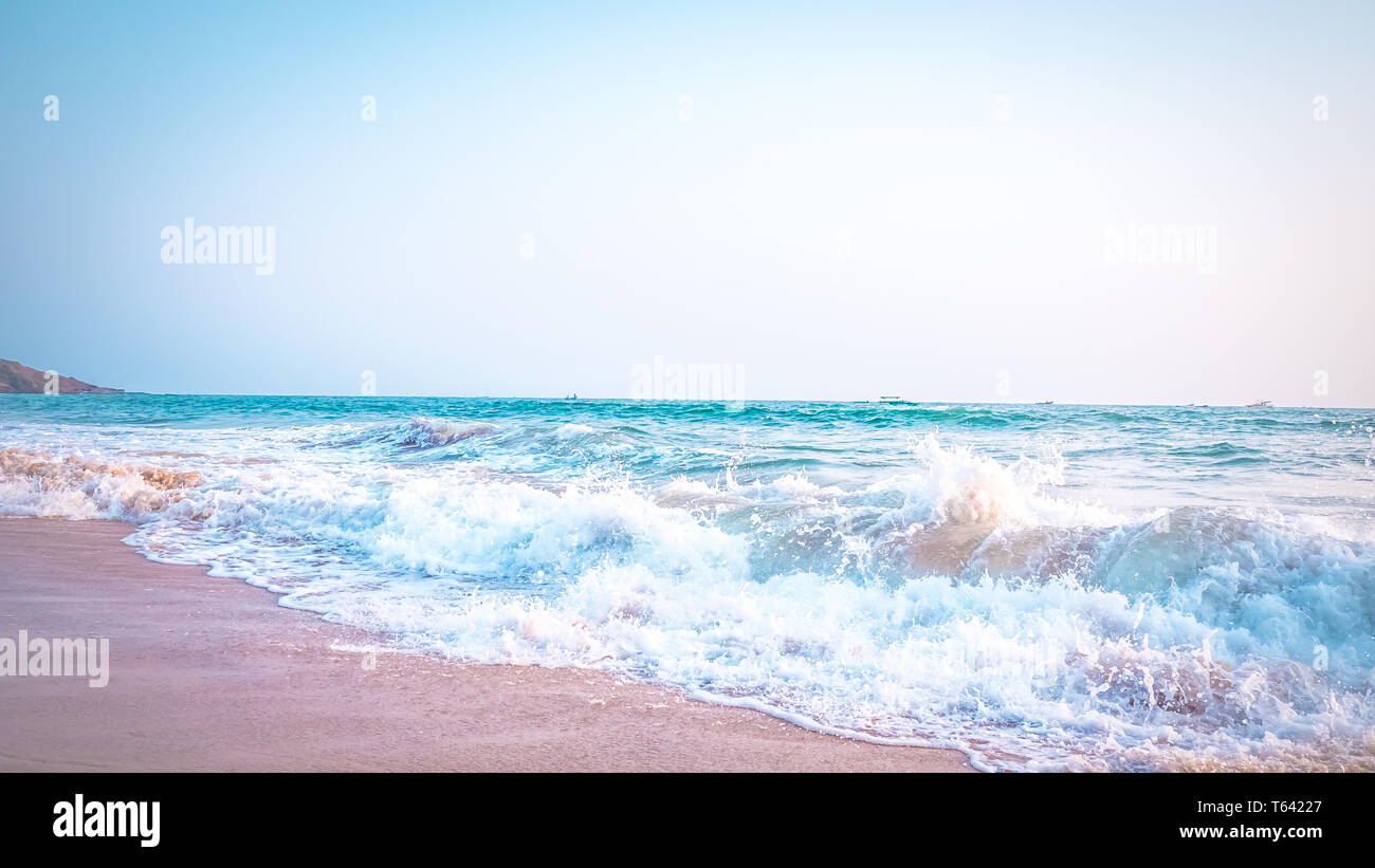 Schöne Anjuna Beach im Norden von Goa, Indien. Beliebte strand ferien Destination in Goa mit blau Arabische Meer Wellen, Felsen, und typische Strand Stockfoto
