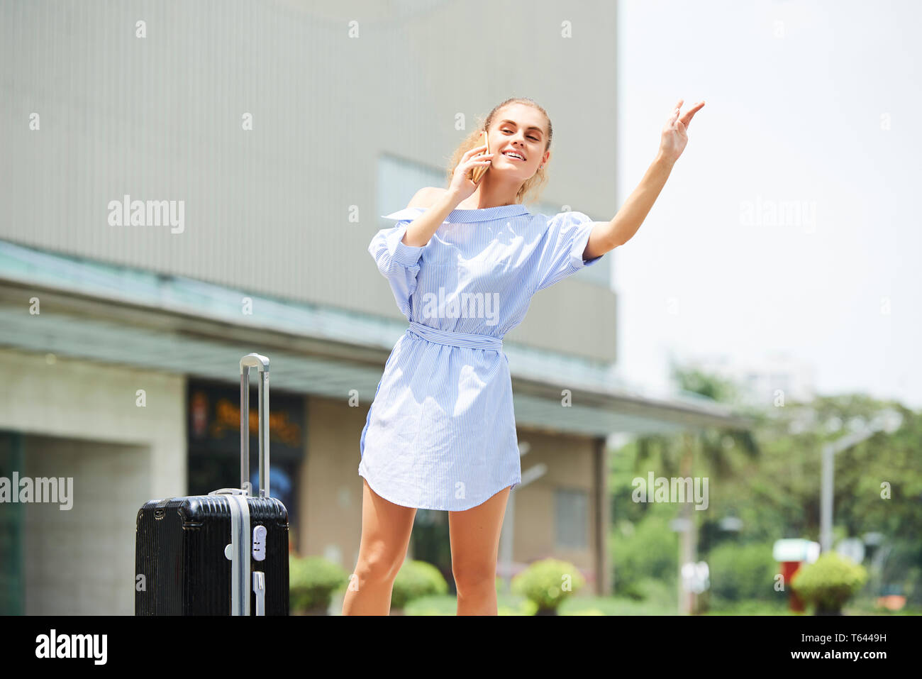 Hübsche Frau Fang mit dem Taxi zum Flughafen. Stockfoto