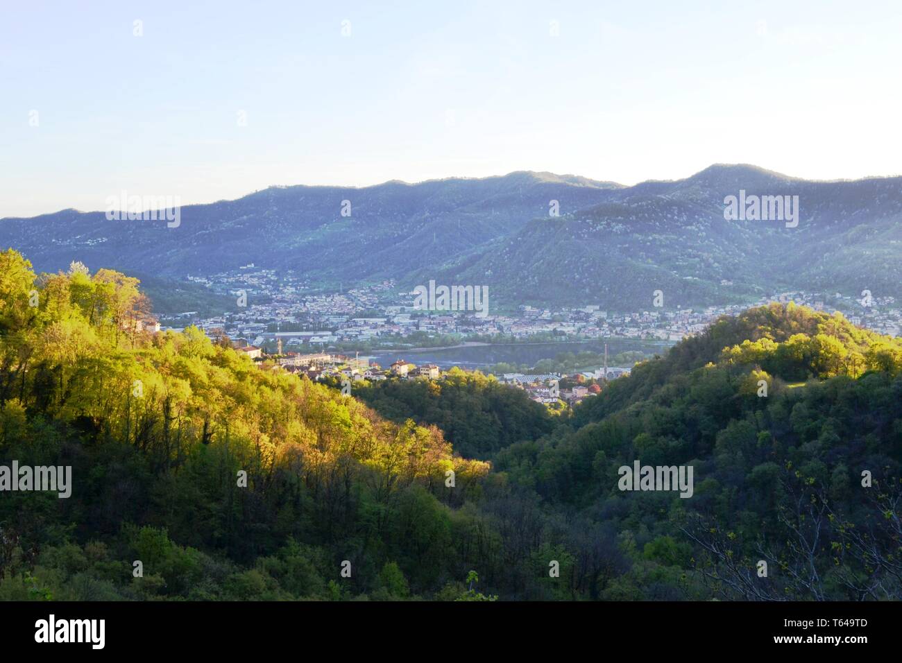 Schöner Panoramablick von der Straße auf den Wald auf hohen Bergen zu Erve, Calolziocorte und Garlate See, Rossino Burg in frühen Abend im Frühling. Stockfoto