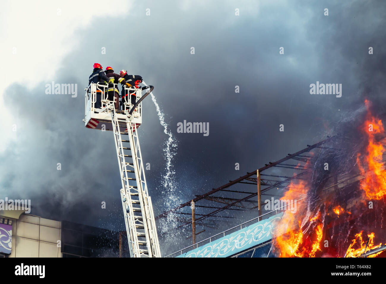 Feuerwehrmänner ein großes Feuer löschen Stockfoto