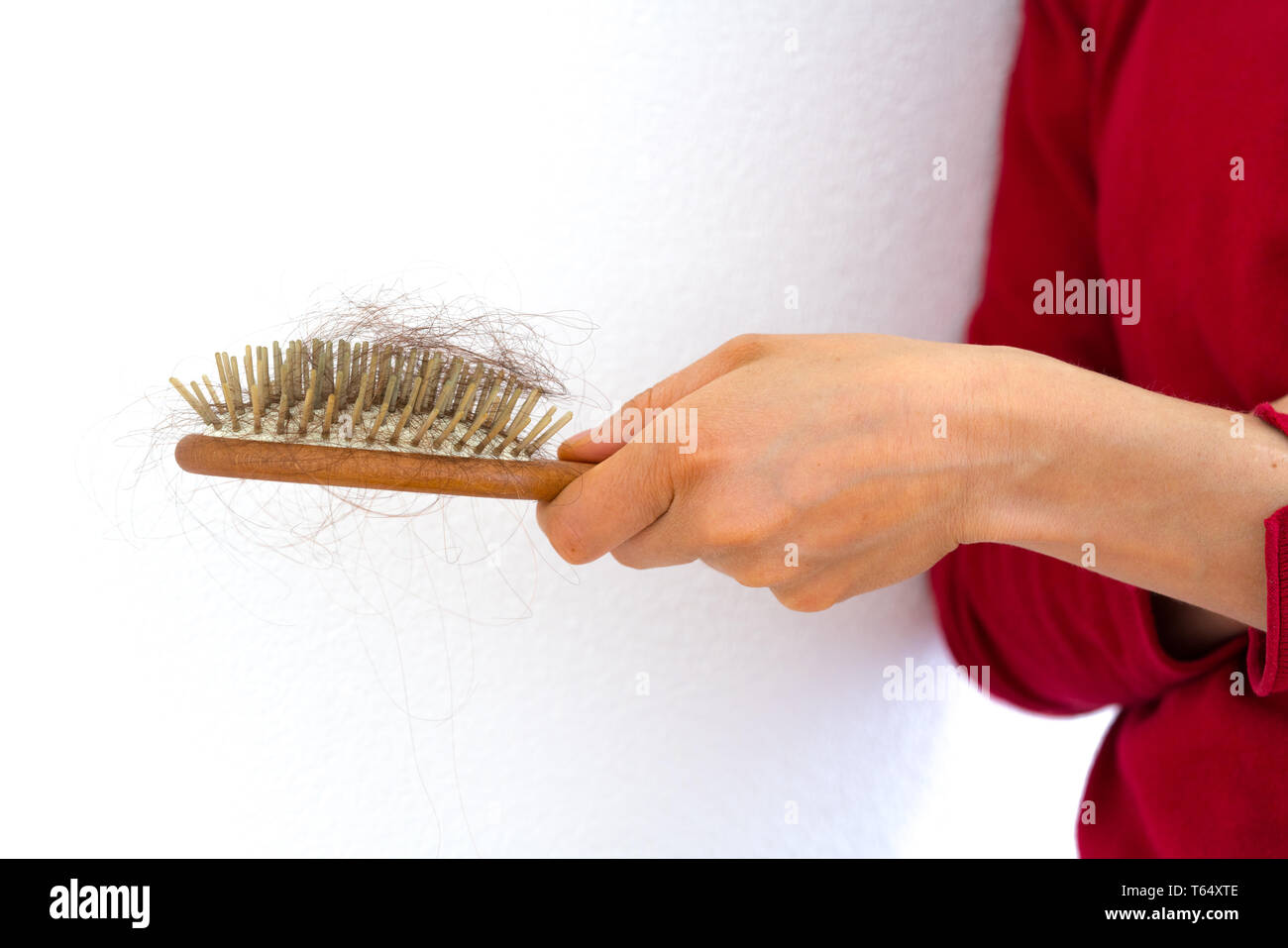 Detail horizontale Ansicht für eine weibliche Hand, die eine Haarbürste voller Haar, weil der Haarausfall Problem Stockfoto
