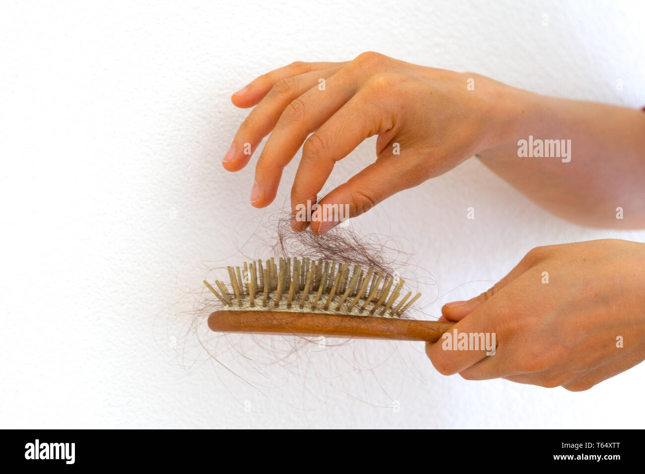 Detail horizontale Ansicht der weiblichen Händen Haar Entnahme aus Holz Haarbürste, weil der Haarausfall Problem Stockfoto