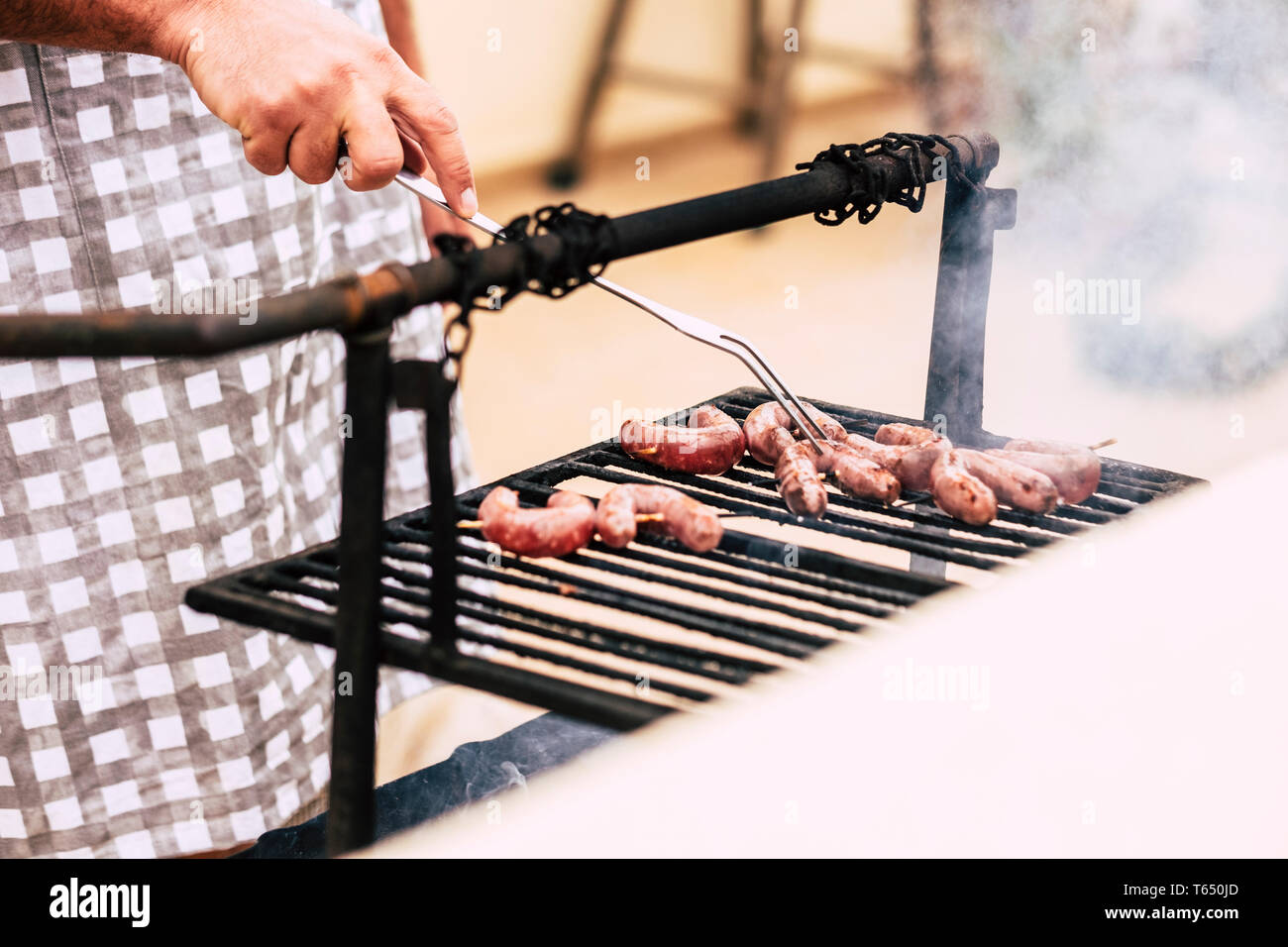 Nahaufnahme des Menschen Hände kochen frisches Fleisch auf einem alten Stil Holz und Feuer Grill BBQ Grill - home Feier für Leute, die gerne essen und mit frie genießen Stockfoto