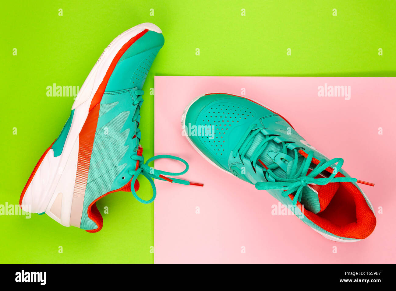 Rot, hellblau, weiß, Paar neue Tennisschuhe im Studio Schuß über Grün, Rosa Hintergrund. Direkt von oben. Stockfoto