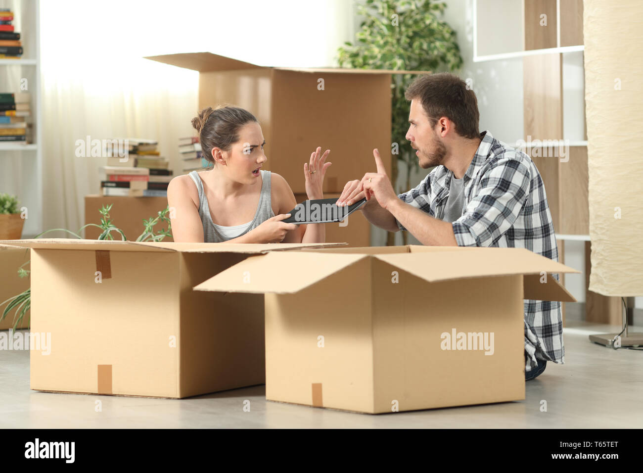Ehe Umzug kämpfen für eine Tablette sitzen auf dem Boden Stockfoto