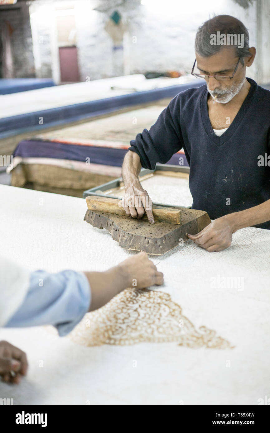 Ein master Drucker druckt ein originelles Design mit Holzschnitt auf Stoff in einer Druckerei in Jaipur, Indien Am 19. Dezember 2013. Holzschnitt ist Stockfoto