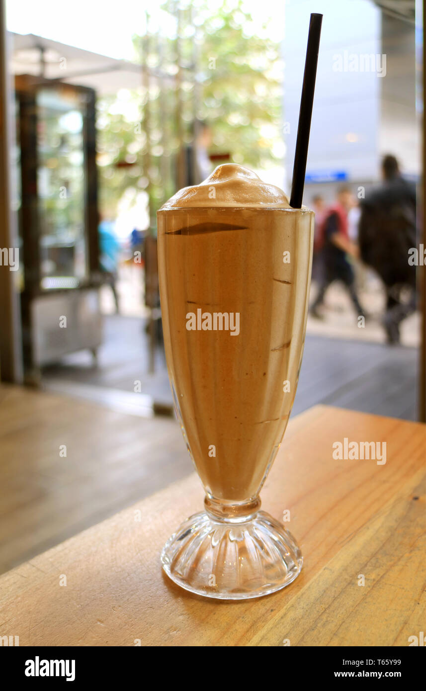 Glas frappe Kaffee auf dem Tisch mit einer geschäftigen Stadt Szene im Hintergrund Stockfoto