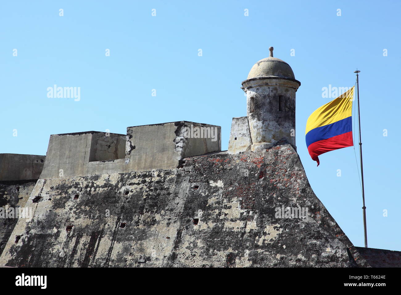 Kolumbianische Flagge auf der dicken Mauern vom Aussichtsturm der Burg San Felipe de Barajas, östlich der Stadtmauer von Cartagena in Kolumbien Stockfoto