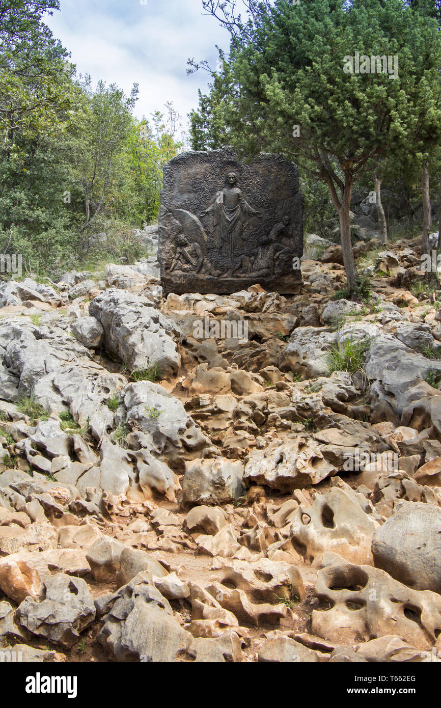 Bronze Relief am Erscheinungsberg Podbrdo mit Blick auf das Dorf von Medjugorje in Bosnien und Herzegowina Stockfoto