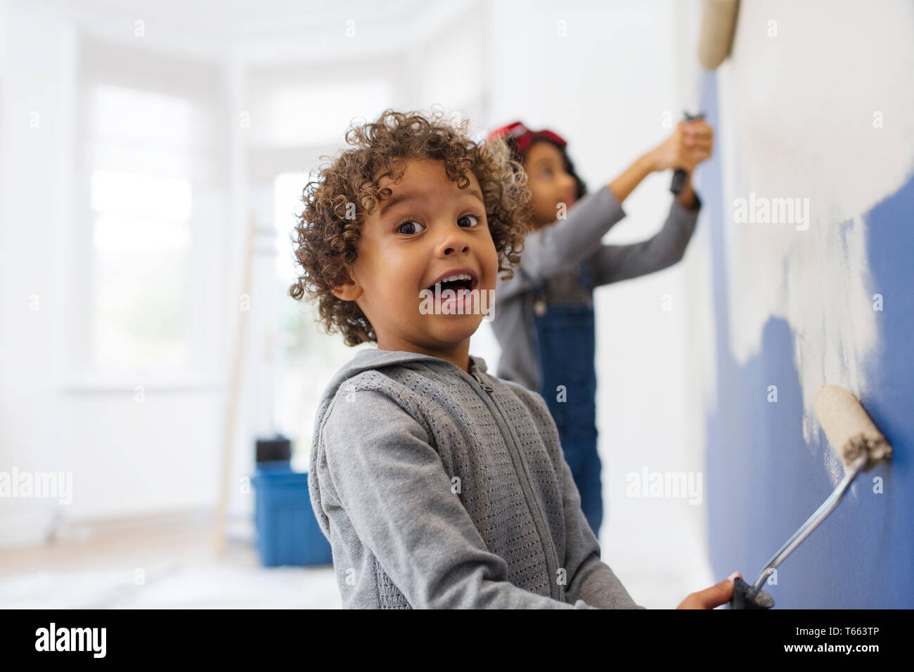 Portrait Süße, verspielte junge Malerei Wand Stockfoto