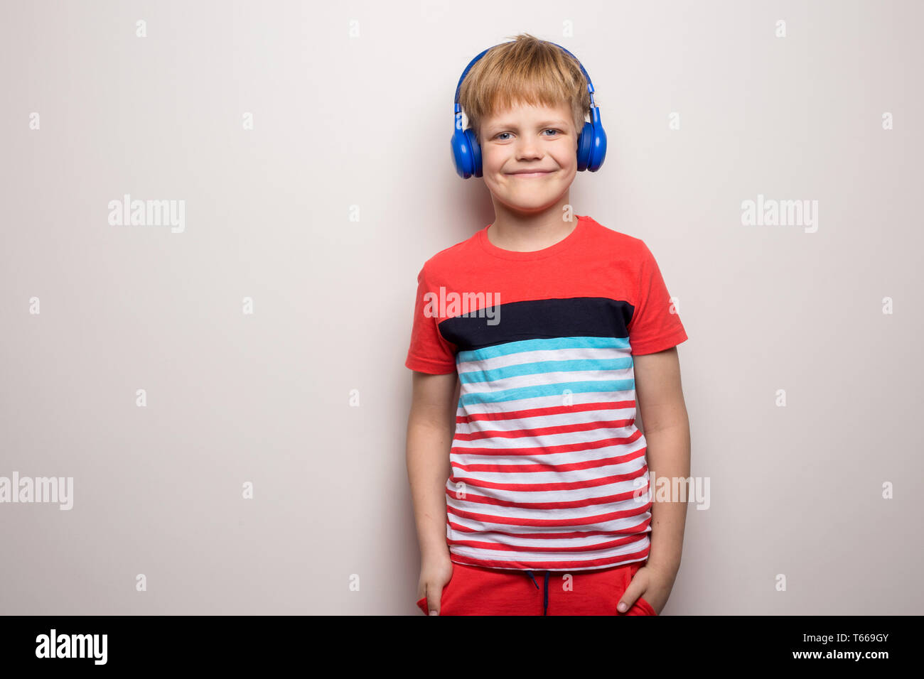 Kid Studio Schießen können Sie über Kopfhörer Musik hören. Auf weissem Hintergrund Stockfoto