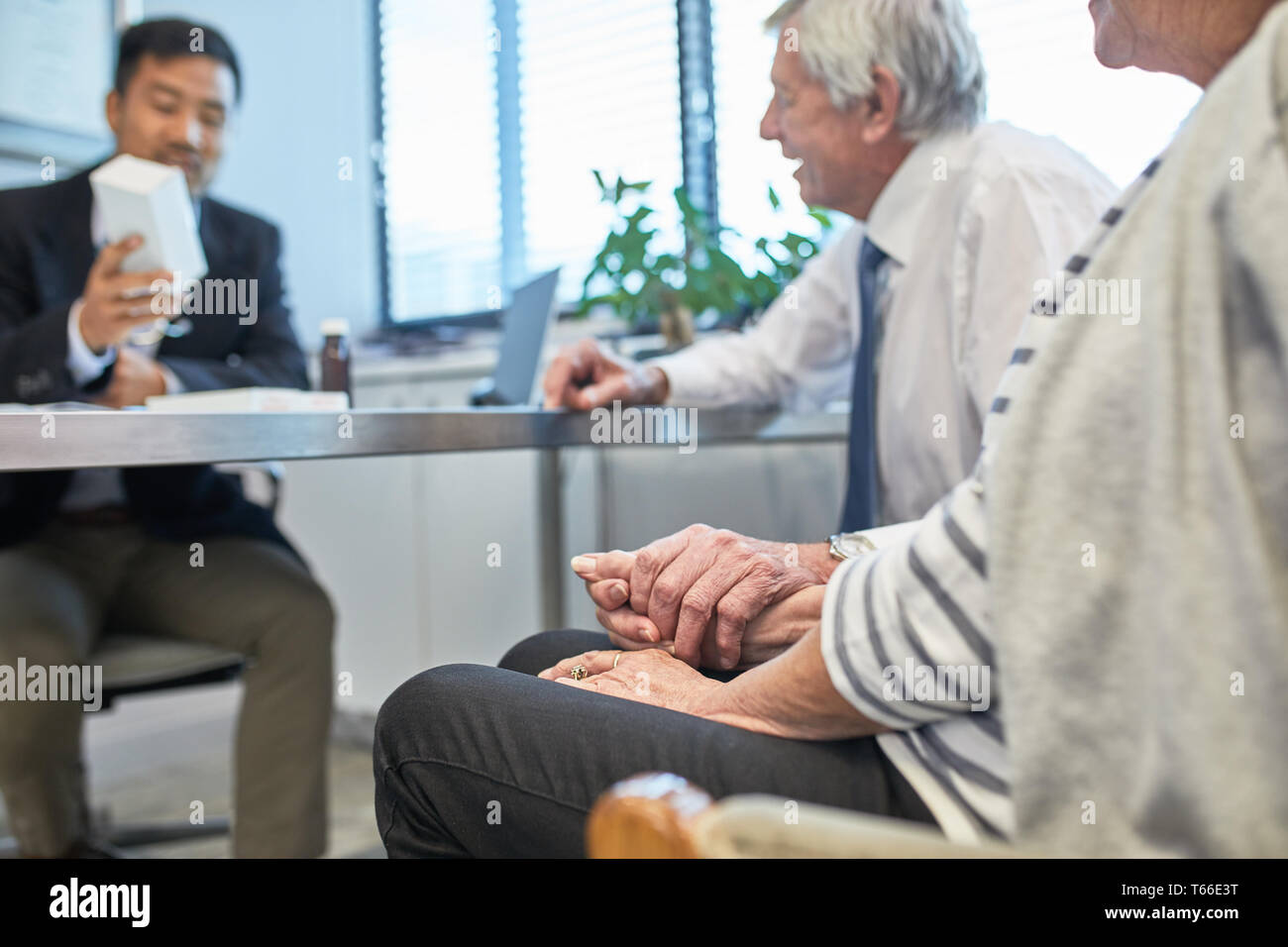 Arzt im Gespräch mit dem Senior Paar in Klinik Ärzte Büro Stockfoto