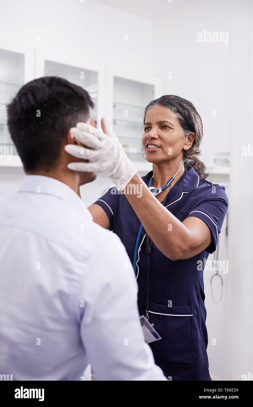 Ärztin Prüfung männlicher Patient in der Klinik Untersuchungsraum Stockfoto