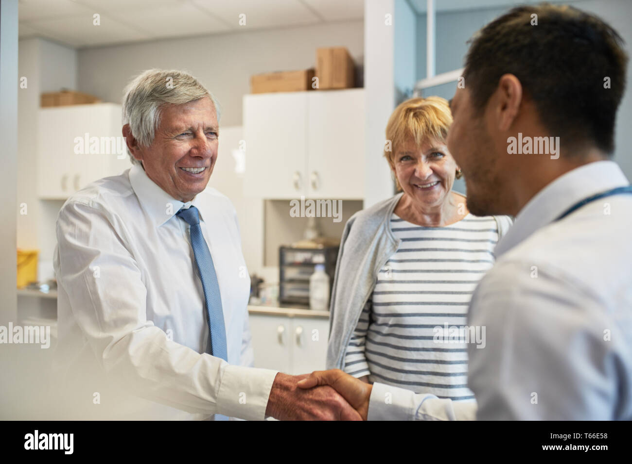Arzt Händeschütteln mit Senior Paar in Klinik Untersuchungsraum Stockfoto