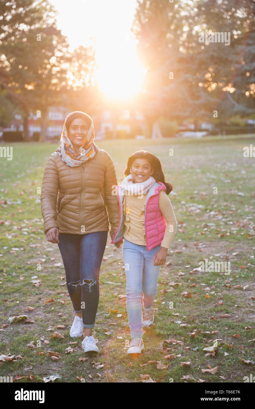 Portrait happy muslimische Mutter und Tochter wandern im sonnigen Herbst Park Stockfoto