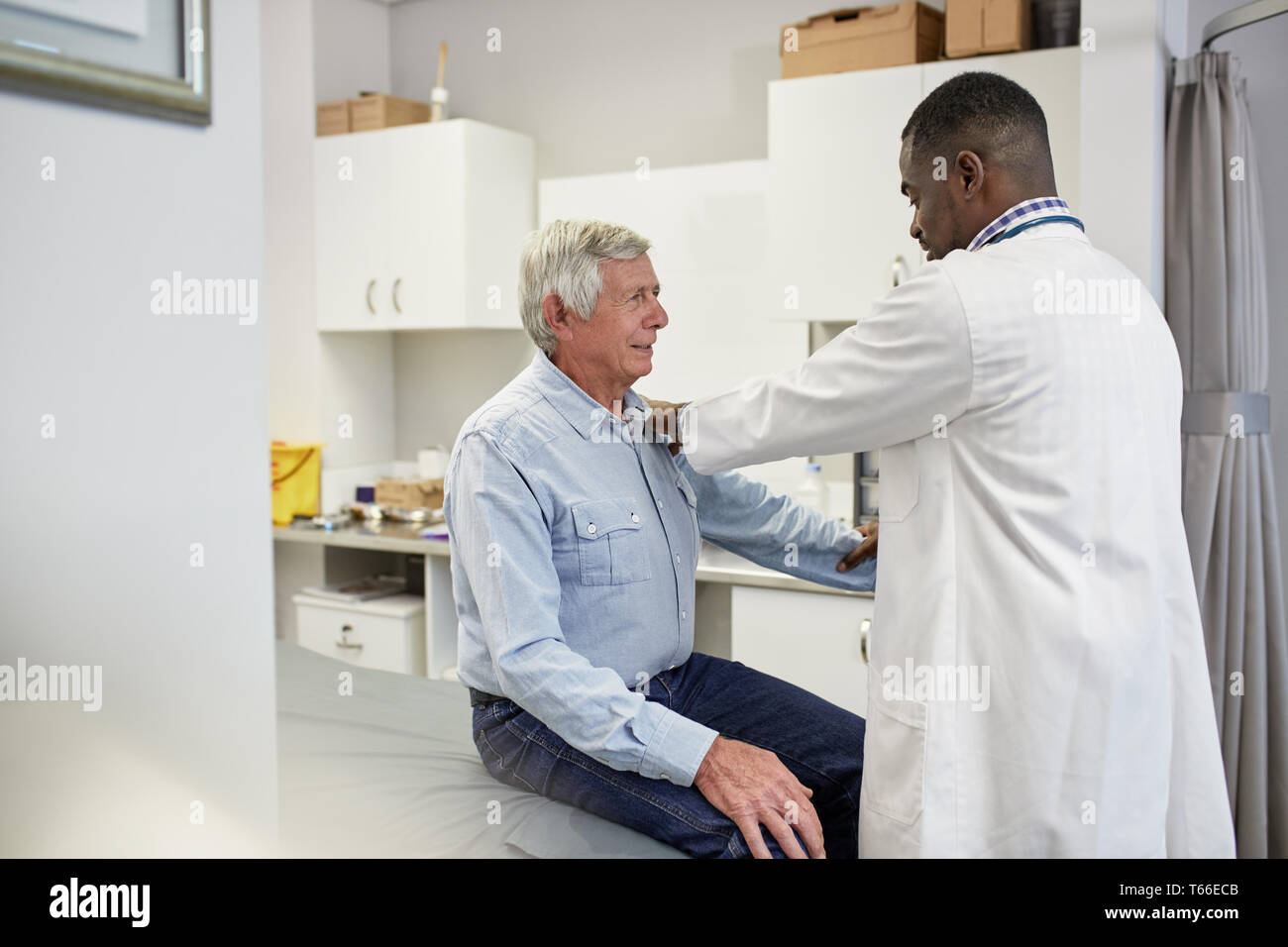 Männlicher Arzt Prüfung älterer Patienten in Klinik Untersuchungsraum Stockfoto