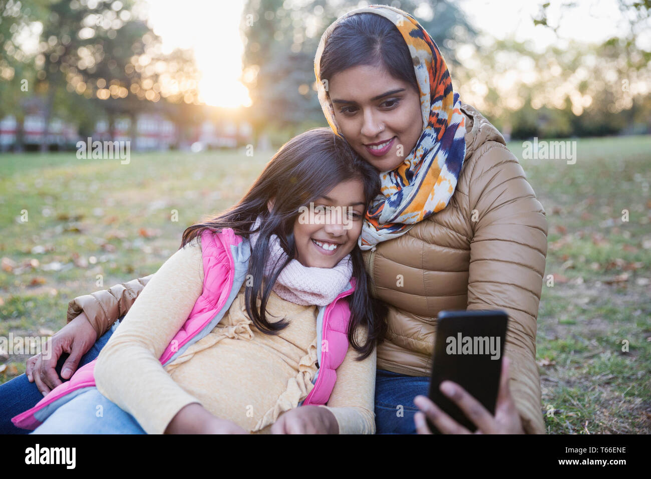 Muslimische Mutter im hijab unter selfie mit Tochter im Herbst Park Stockfoto