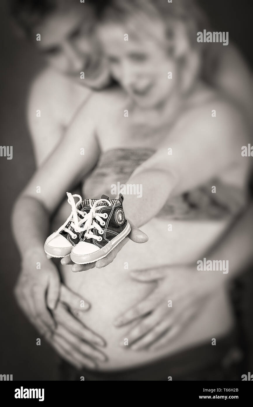 Schwangere Frau und Mann mit ein kinderschuh Stockfoto