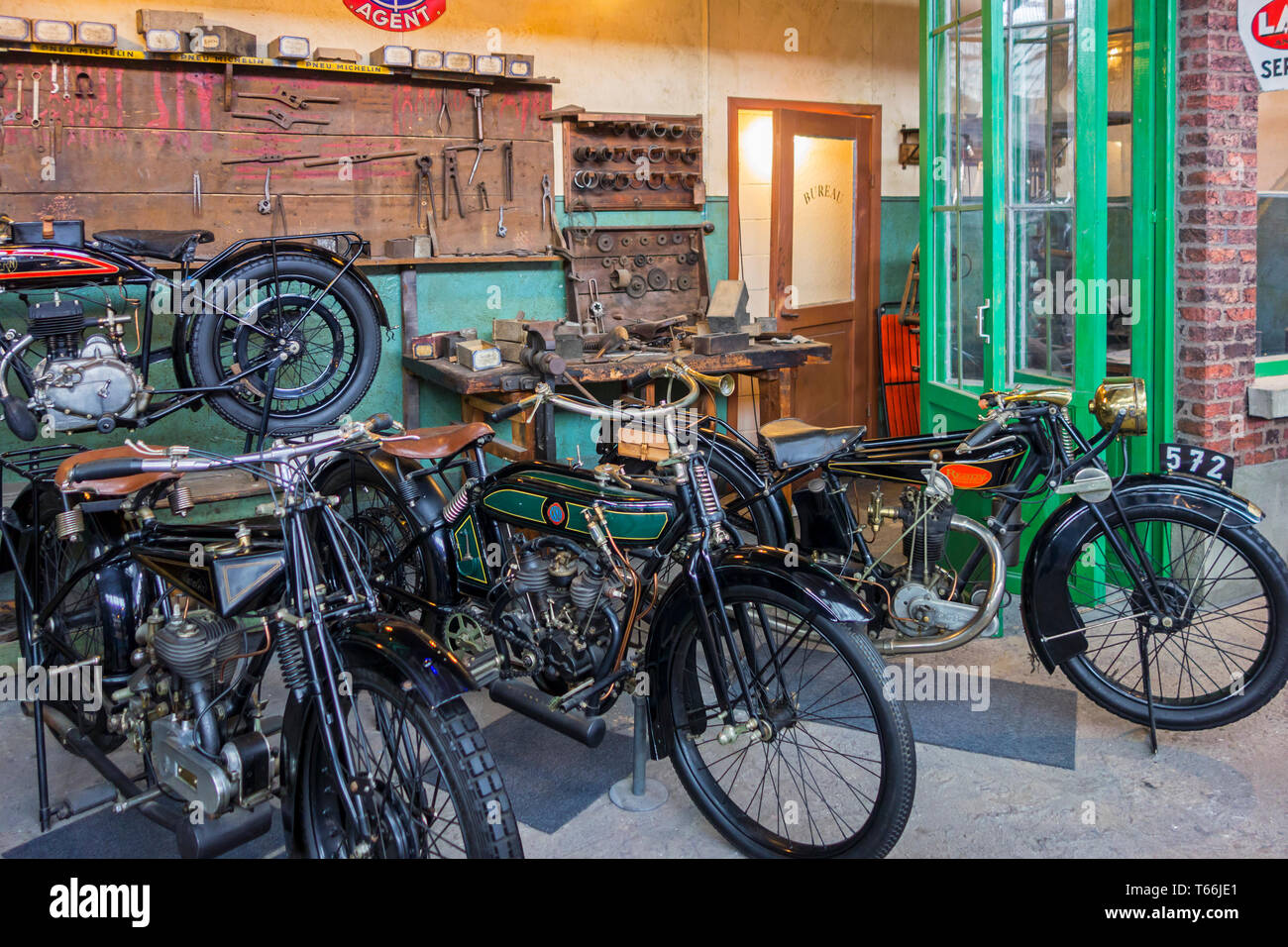 Diorama von alten Werkstatt zeigt klassische Motorräder, antiken Motorräder und Oldtimer in der Autoworld Oldtimer Museum in Brüssel, Belgien Stockfoto