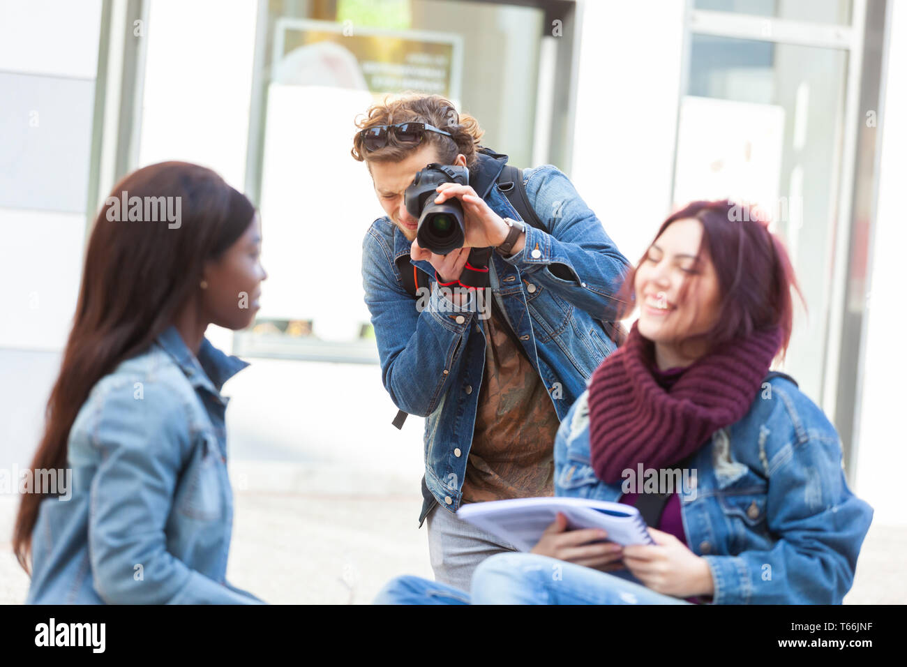 Junge Fotografen Fotografieren von zwei Mädchen beim Studieren. Stock Fotografie Konzept. Stockfoto
