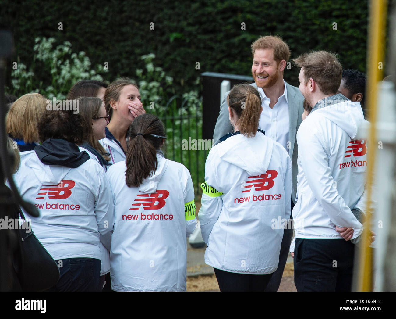 Prinz Harry gesehen lachend mit Freiwilligen vor der Siegerehrung am Virgin London Marathon 2019 in London. Stockfoto