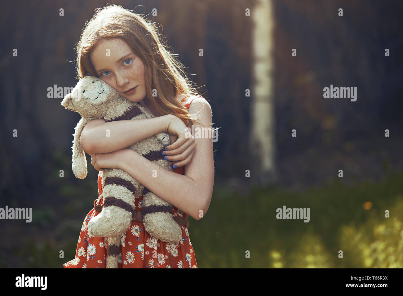 Portrait serene tween Girl mit ausgestopften Tier im Park Stockfoto