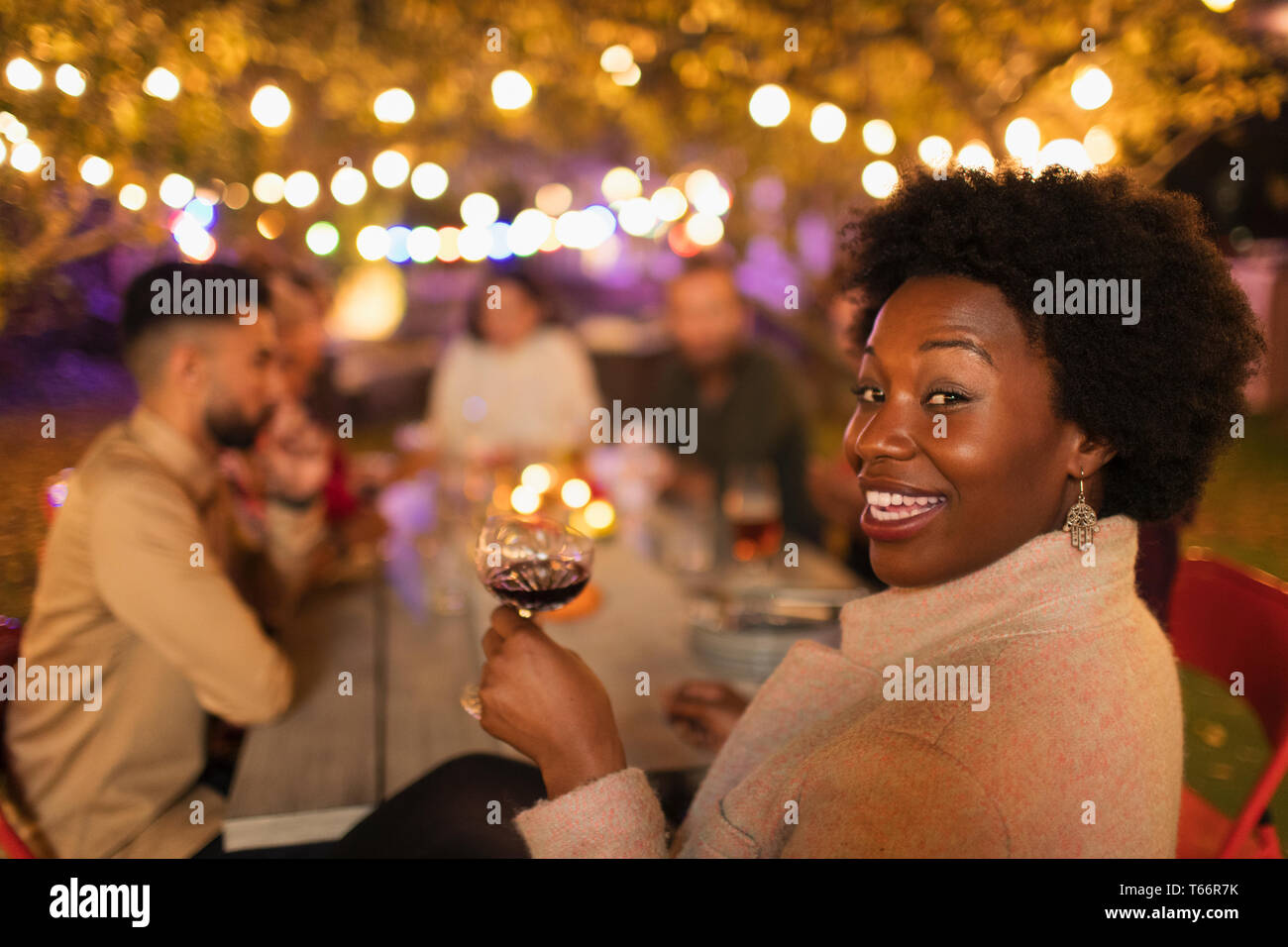 Portrait glückliche Frau, Wein trinken, genießen das Abendessen Garden Party Stockfoto