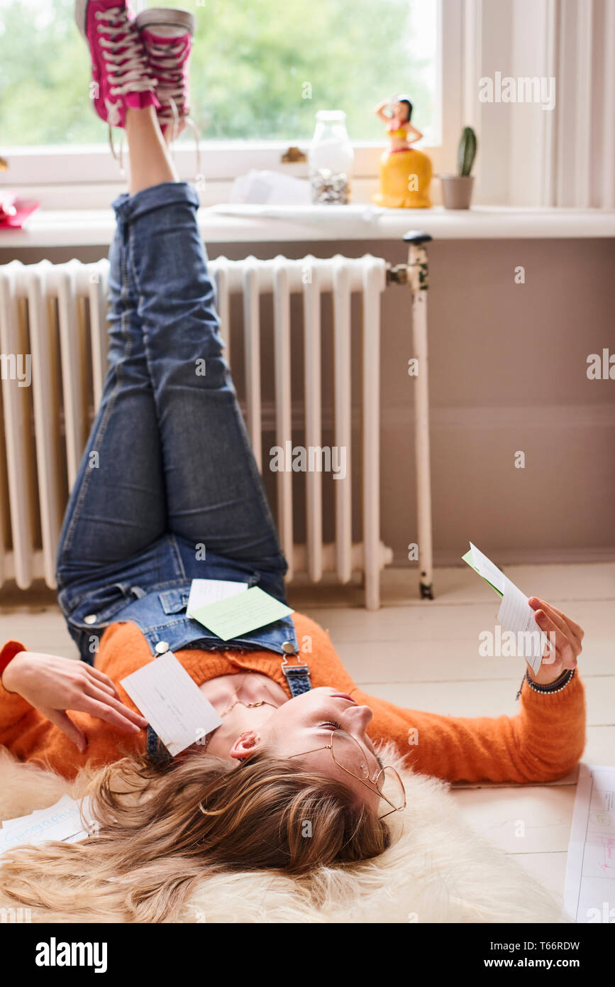 Junge weibliche Studenten studieren mit Flash Cards auf dem Boden Stockfoto