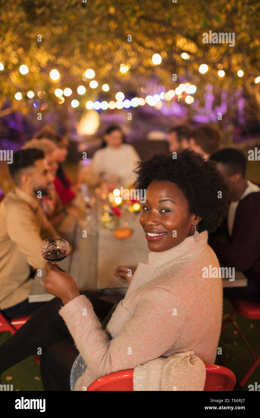 Portrait glückliche Frau, Wein trinken, genießen das Abendessen Garden Party Stockfoto