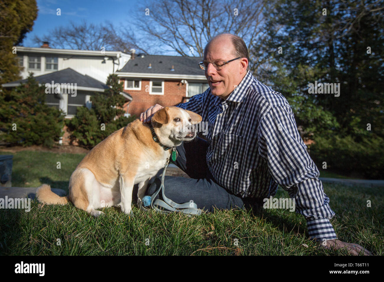 Senior Fellow bei der Ethics and Public Policy Center, Peter Wehner mit dem Hund der Familie Romeo. Stockfoto