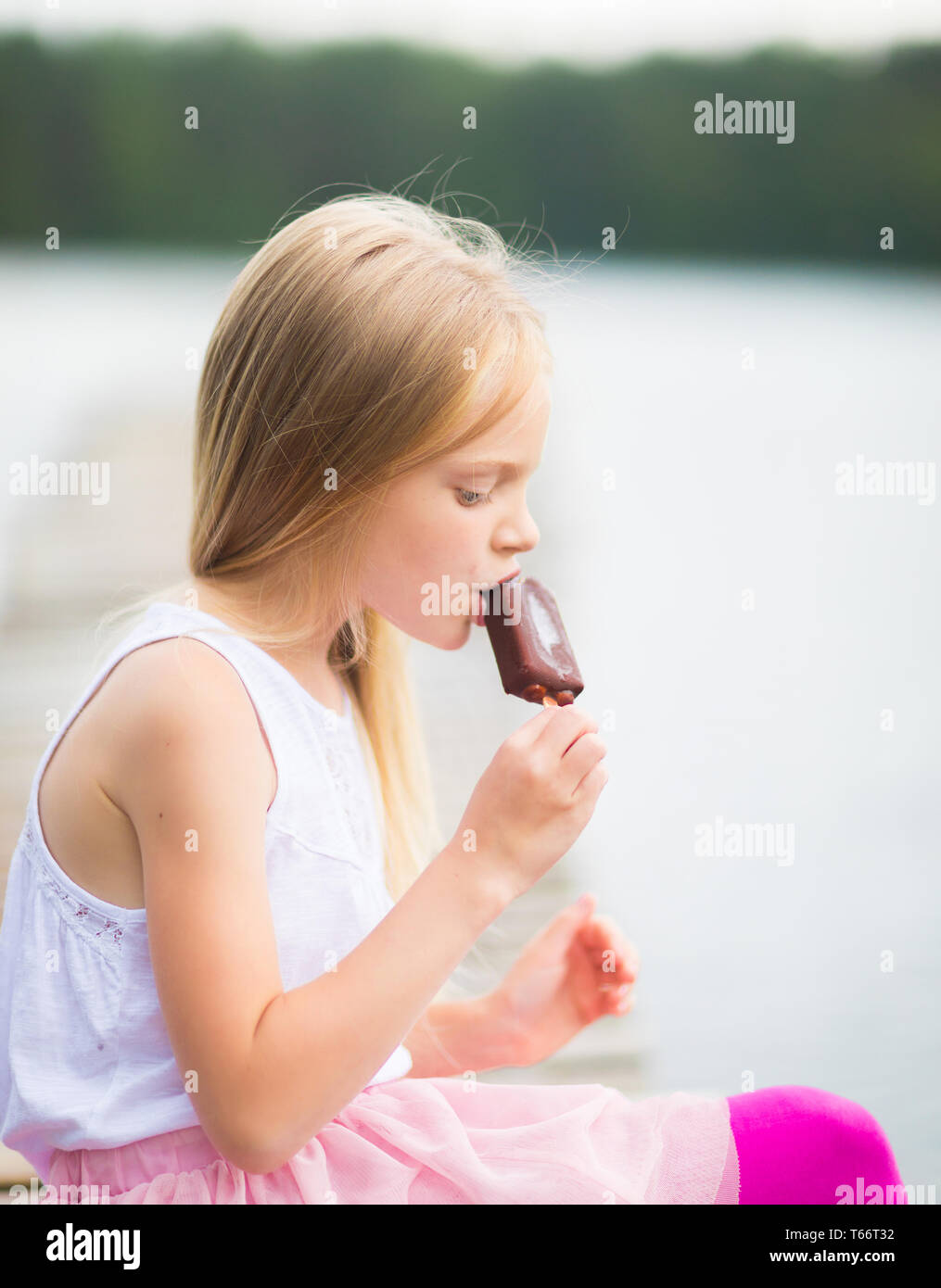 Kleines Mädchen isst Stick ice cream bar Eskimo Pie Stockfoto
