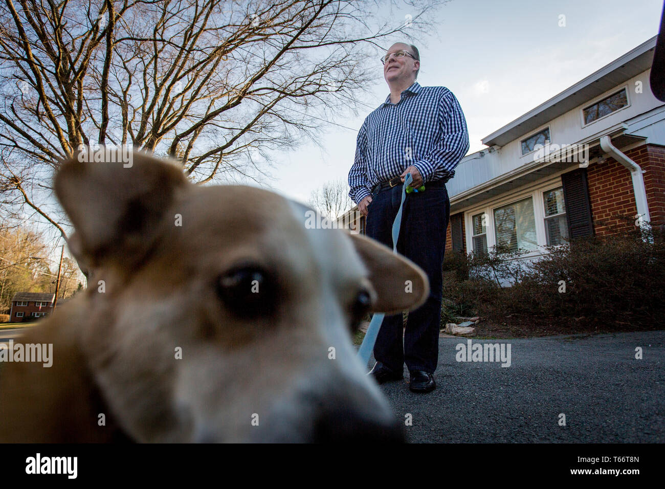 Senior Fellow bei der Ethics and Public Policy Center, Peter Wehner mit dem Hund der Familie Romeo. Stockfoto