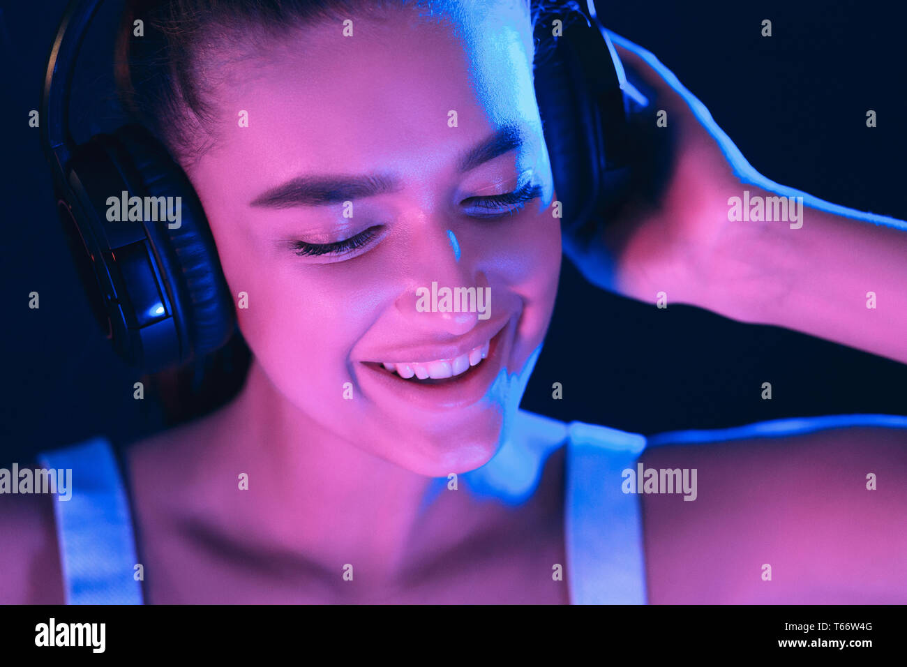 DJ im Club. Frau in Headset Musik hören, mit Neonlicht beleuchtet Stockfoto